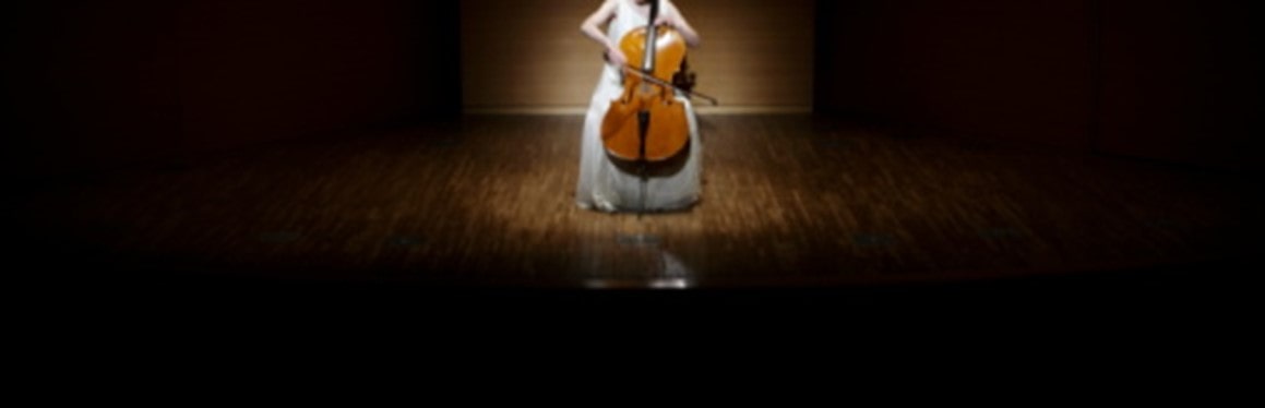Violin player under a spotlight, visualizing the concept of only using what you need