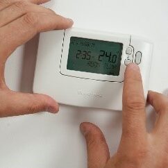 hand turning down thermostat 